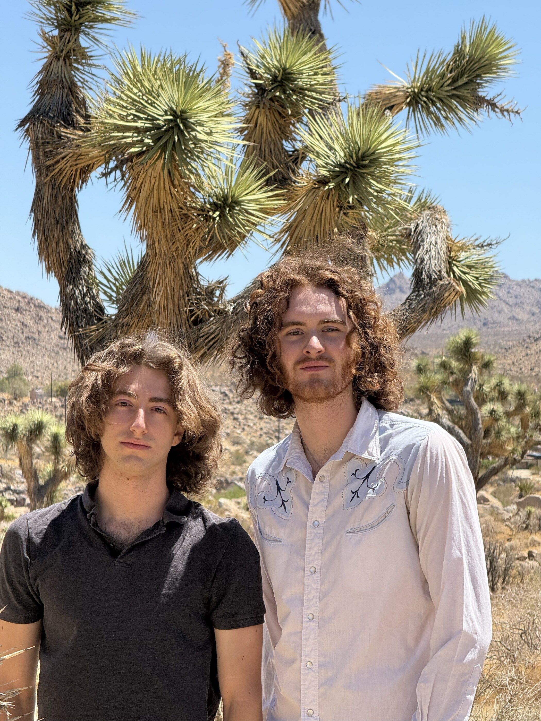 Elijah Morton and Joaquim Timoner standing in front of a Joshua tree in the desert.